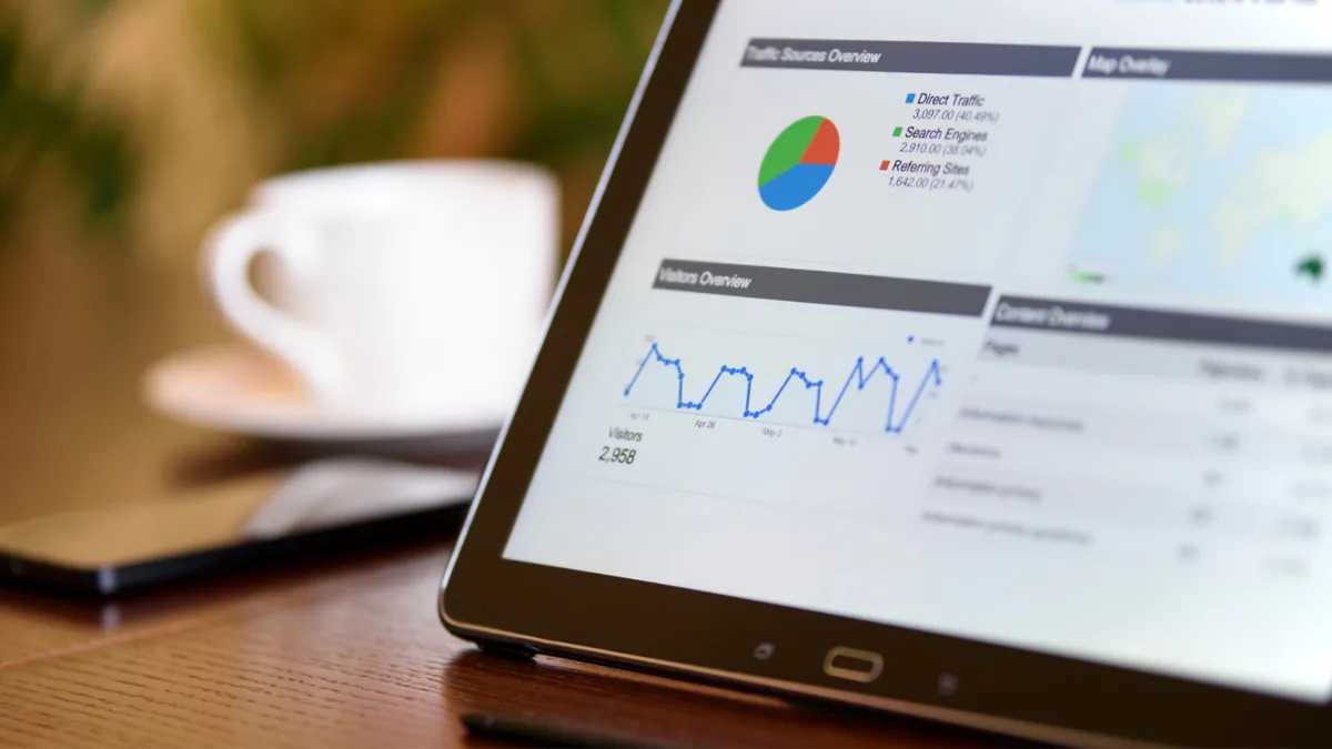 Tablet on a desk showing an analytics dashboard with charts and a map